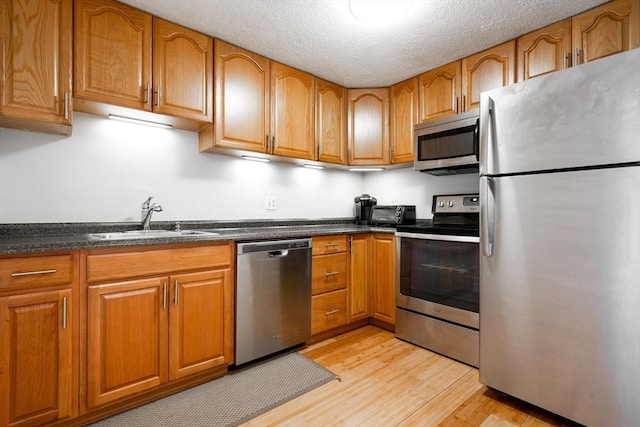 kitchen featuring brown cabinets, stainless steel appliances, and a sink