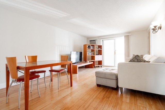 living room featuring light wood-type flooring and a textured ceiling