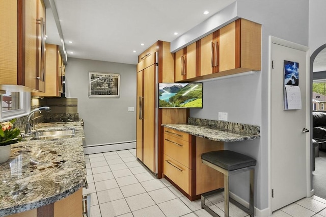 4 Polito Dr, Worcester, MA 01604 - kitchen with a sink, a baseboard radiator, light tile patterned flooring, paneled fridge, and light stone countertops