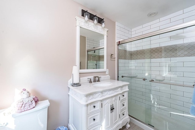 bathroom with vanity, an enclosed shower, and toilet