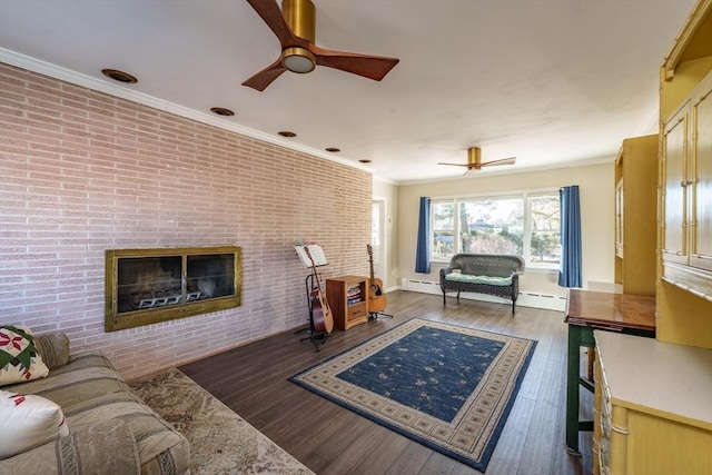 living room featuring hardwood / wood-style floors, crown molding, ceiling fan, and a baseboard heating unit