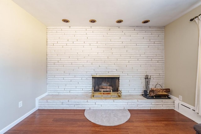 interior details featuring a brick fireplace and hardwood / wood-style flooring