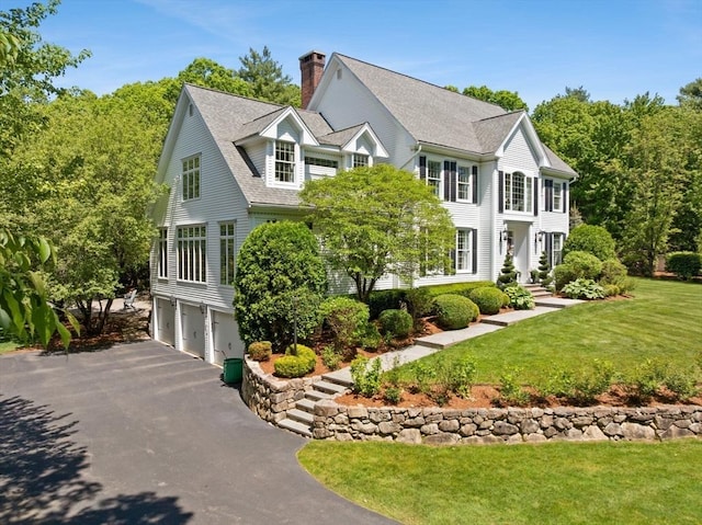8 Riverside Ter, Easton, MA 02356 - colonial-style house featuring a garage, driveway, a chimney, a front yard, and a shingled roof