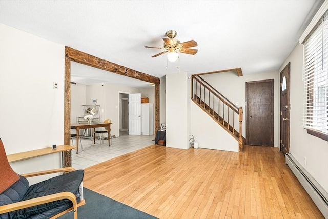 98 G St, Dracut, MA 01826 - living room with a baseboard heating unit, light wood-style flooring, stairs, a ceiling fan, and healthy amount of natural light