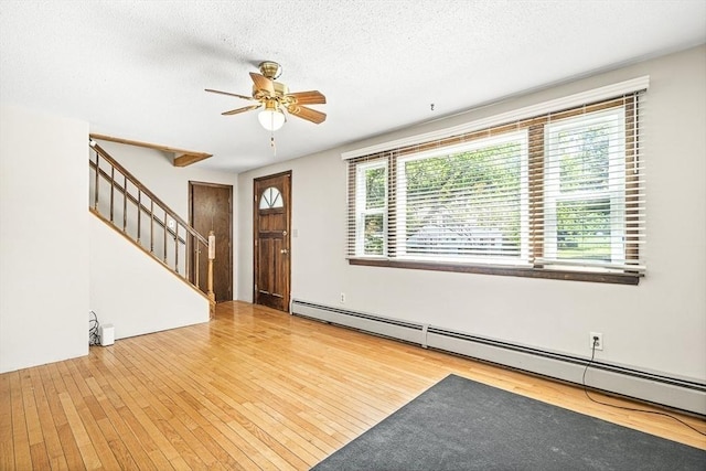 98 G St, Dracut, MA 01826 - entrance foyer with a ceiling fan, a baseboard heating unit, stairway, hardwood / wood-style floors, and a textured ceiling