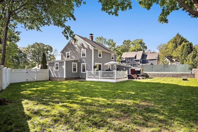 back of property featuring a gate, a chimney, and a deck