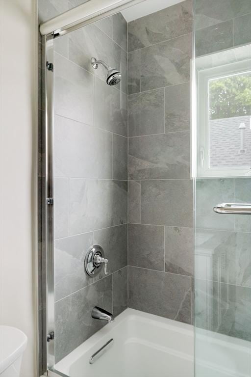full bath featuring enclosed tub / shower combo and toilet