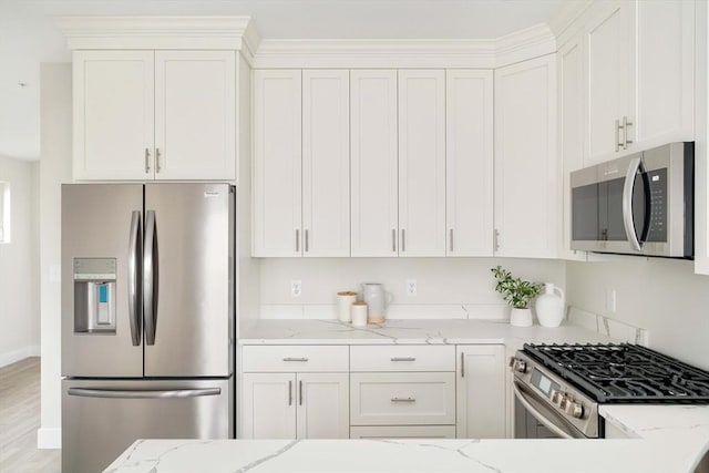 kitchen with appliances with stainless steel finishes, light stone countertops, and white cabinets