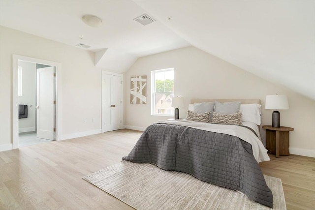 bedroom featuring wood finished floors, lofted ceiling, and baseboards