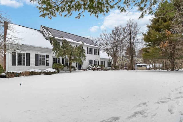 view of snow covered back of property