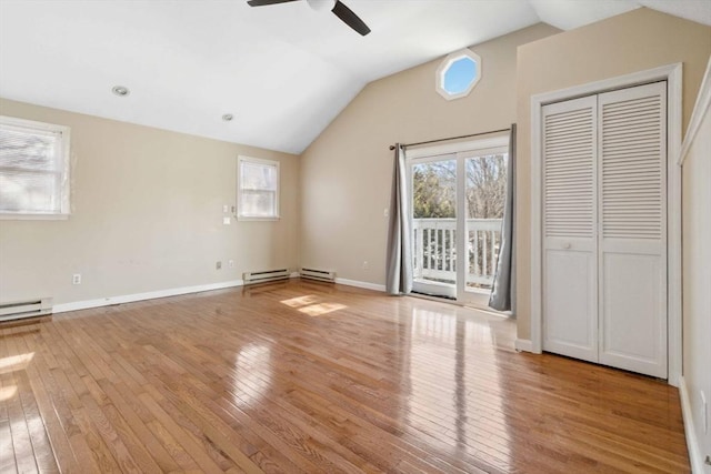 interior space featuring lofted ceiling, hardwood / wood-style flooring, a ceiling fan, baseboards, and access to exterior