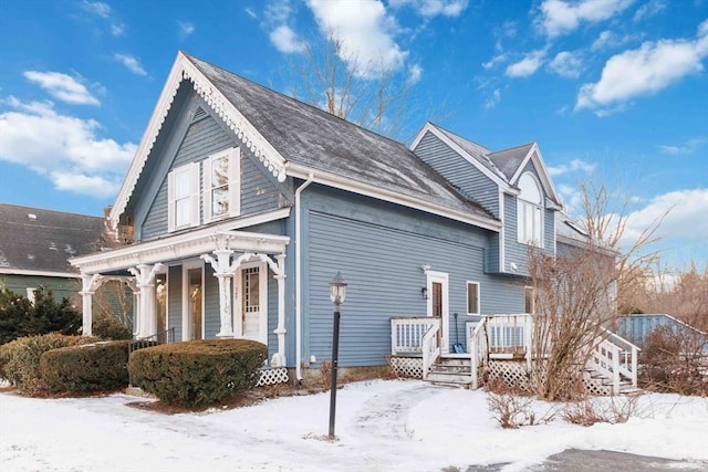 snow covered property with a porch