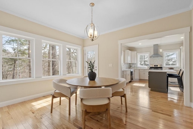 dining room with a notable chandelier, light wood-type flooring, baseboards, and ornamental molding