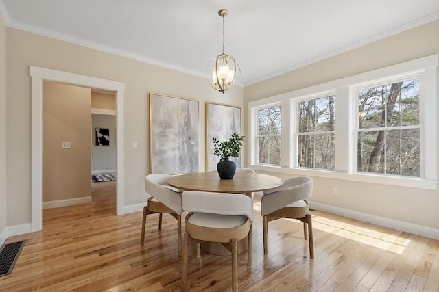 dining area featuring baseboards, light wood-style floors, visible vents, and ornamental molding