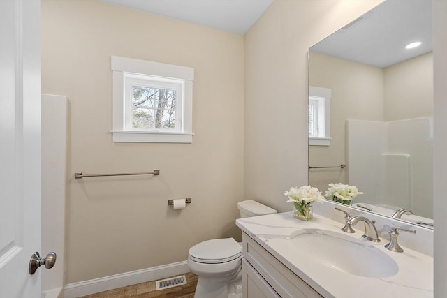 bathroom featuring vanity, toilet, baseboards, and visible vents