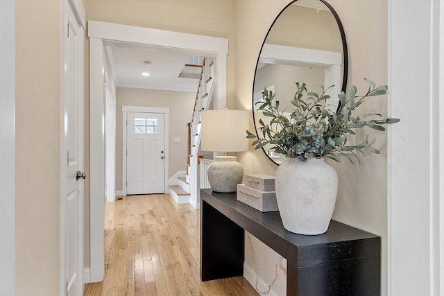 entrance foyer with baseboards, stairs, and light wood finished floors