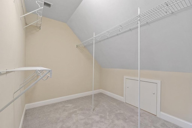 spacious closet featuring visible vents, carpet, and vaulted ceiling