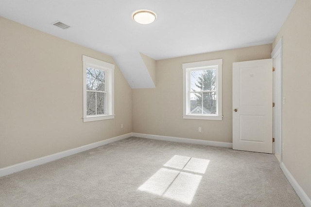 additional living space with visible vents, plenty of natural light, baseboards, and carpet floors