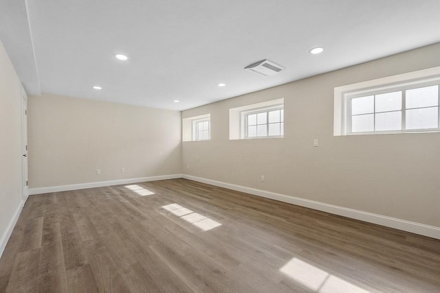 empty room featuring recessed lighting, baseboards, and wood finished floors