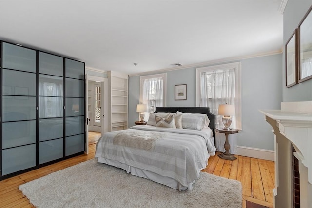 bedroom featuring light wood-type flooring and ornamental molding