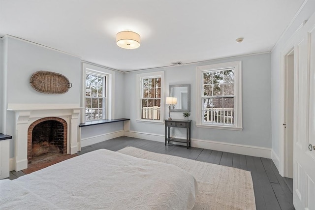 bedroom with crown molding, dark hardwood / wood-style floors, and a fireplace