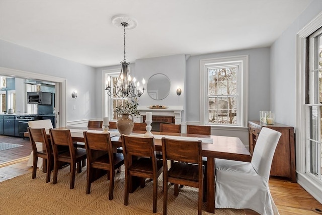 dining space with light wood-type flooring and an inviting chandelier