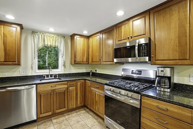 13 Delaval Rd, Worcester, MA 01606 - kitchen featuring appliances with stainless steel finishes, a sink, light tile patterned floors, brown cabinetry, and dark stone counters