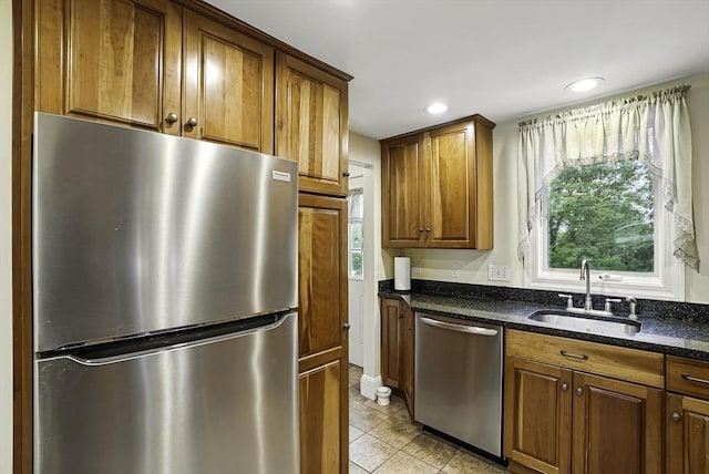 13 Delaval Rd, Worcester, MA 01606 - kitchen with appliances with stainless steel finishes, a sink, brown cabinetry, dark stone countertops, and light tile patterned floors