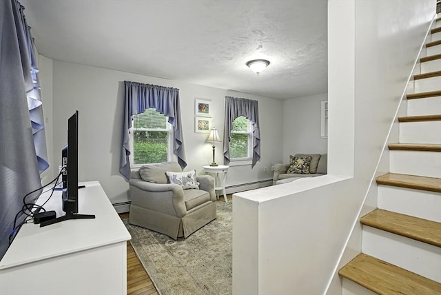 13 Delaval Rd, Worcester, MA 01606 - living area featuring stairway, wood finished floors, a baseboard heating unit, and a textured ceiling
