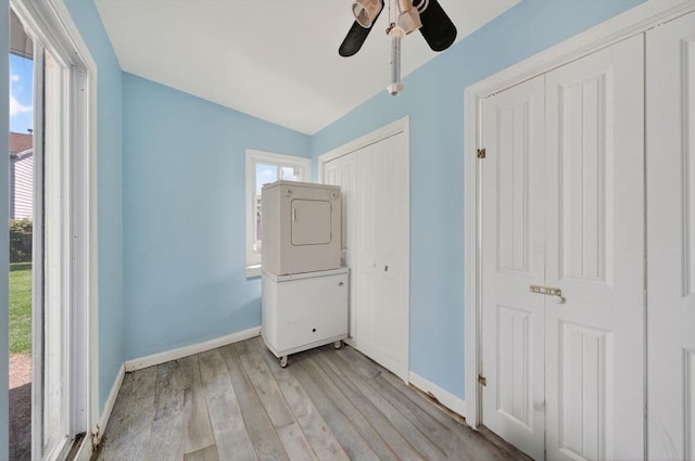 42 Mccabe St, Dartmouth, MA 02748 - unfurnished bedroom featuring estacked washer and dryer, light wood-style flooring, ceiling fan, and a closet