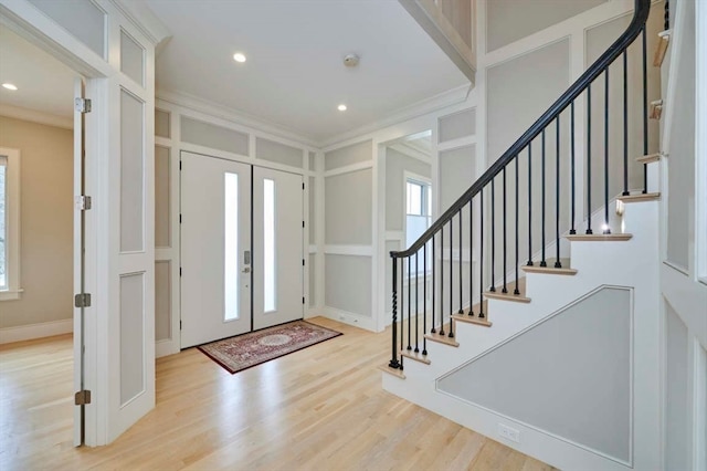 entryway with ornamental molding, light hardwood / wood-style flooring, and french doors