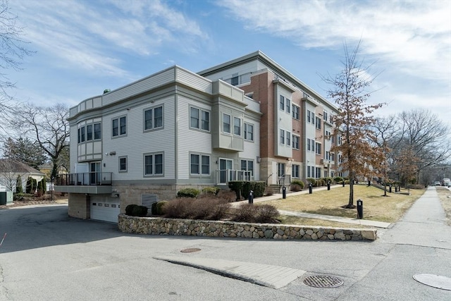 321 Hammond Pond Pkwy Unit U301, Brookline, MA 02467 - view of building exterior with a garage and central AC unit