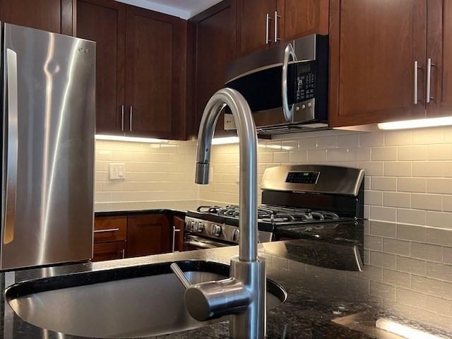 321 Hammond Pond Pkwy Unit U301, Brookline, MA 02467 - kitchen with appliances with stainless steel finishes, tasteful backsplash, and dark stone countertops