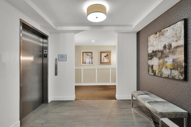 321 Hammond Pond Pkwy Unit U301, Brookline, MA 02467 - hallway with elevator, an accent wall, wood finished floors, and a tray ceiling