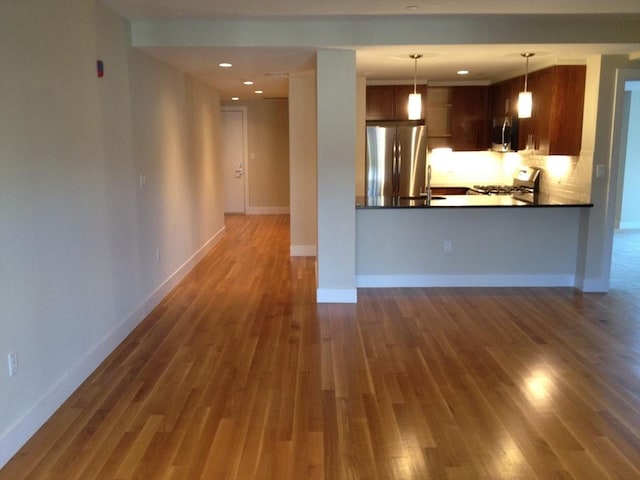 321 Hammond Pond Pkwy Unit U301, Brookline, MA 02467 - kitchen with stainless steel appliances, wood finished floors, dark countertops, a sink, and baseboards