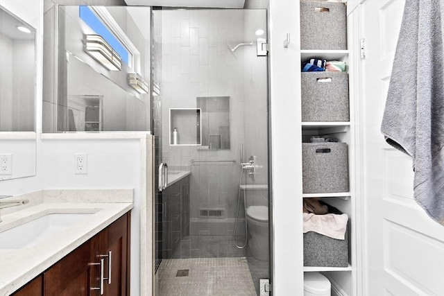 full bath featuring vanity, a shower stall, toilet, and visible vents