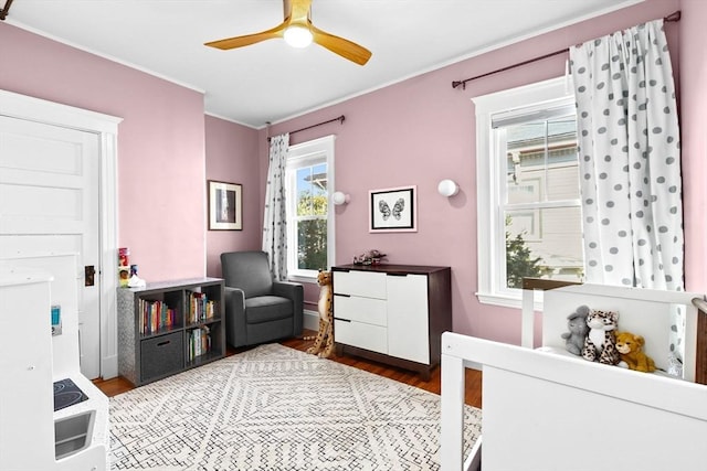 bedroom featuring ornamental molding, a ceiling fan, and wood finished floors