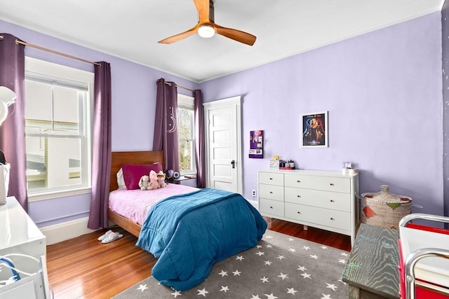 bedroom featuring baseboards, a ceiling fan, and wood finished floors