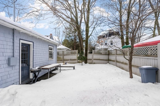 snowy yard featuring a fenced backyard