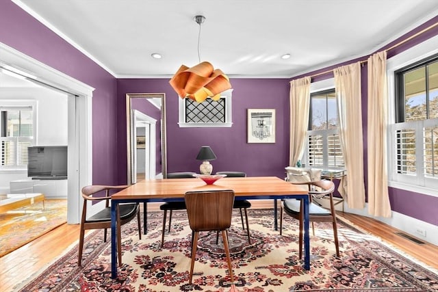 dining space featuring wood finished floors, visible vents, baseboards, recessed lighting, and crown molding