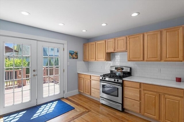 127 Mutton Ln, Weymouth, MA 02189 - kitchen with stainless steel gas stove, light countertops, french doors, light wood-type flooring, and backsplash