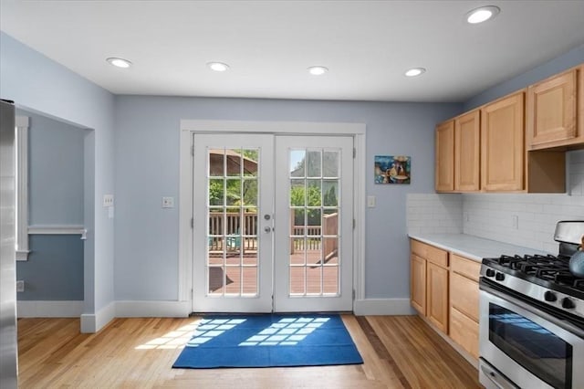 127 Mutton Ln, Weymouth, MA 02189 - kitchen with stainless steel gas range, french doors, light brown cabinetry, light wood-type flooring, and light countertops