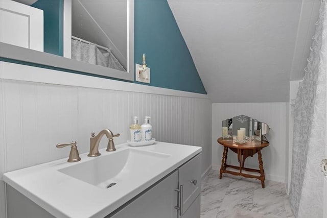 127 Mutton Ln, Weymouth, MA 02189 - bathroom featuring wainscoting, marble finish flooring, vaulted ceiling, and vanity