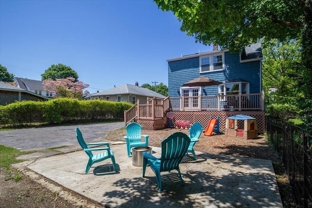 127 Mutton Ln, Weymouth, MA 02189 - view of jungle gym featuring a deck, a fire pit, a patio area, and fence