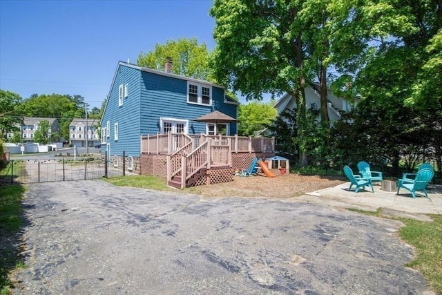 127 Mutton Ln, Weymouth, MA 02189 - rear view of property featuring a deck, a chimney, stairs, fence, and an outdoor fire pit