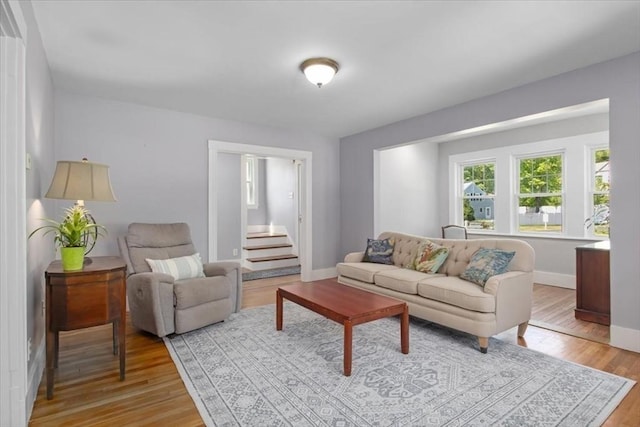 127 Mutton Ln, Weymouth, MA 02189 - living room featuring light wood-style flooring, baseboards, and stairs