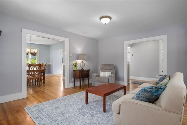 127 Mutton Ln, Weymouth, MA 02189 - living area featuring wood finished floors, a chandelier, and baseboards
