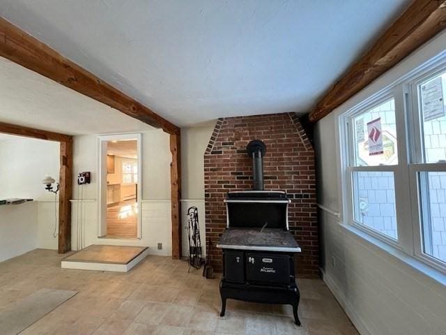 living area featuring a wood stove and beamed ceiling