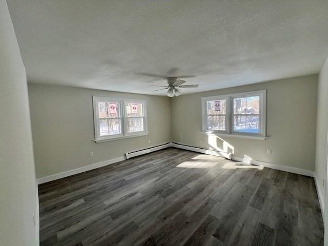 spare room with dark wood-style floors, a wealth of natural light, and baseboards