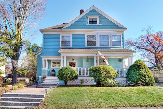 view of front of home with covered porch and a front lawn